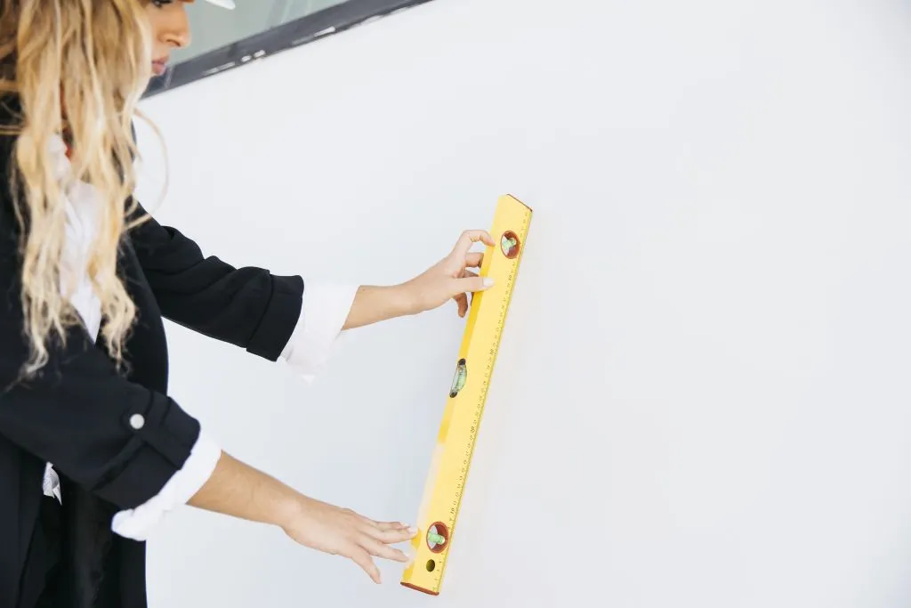 female-architect-on-construction-site-checking-if-wall-is-level.jpg девушка